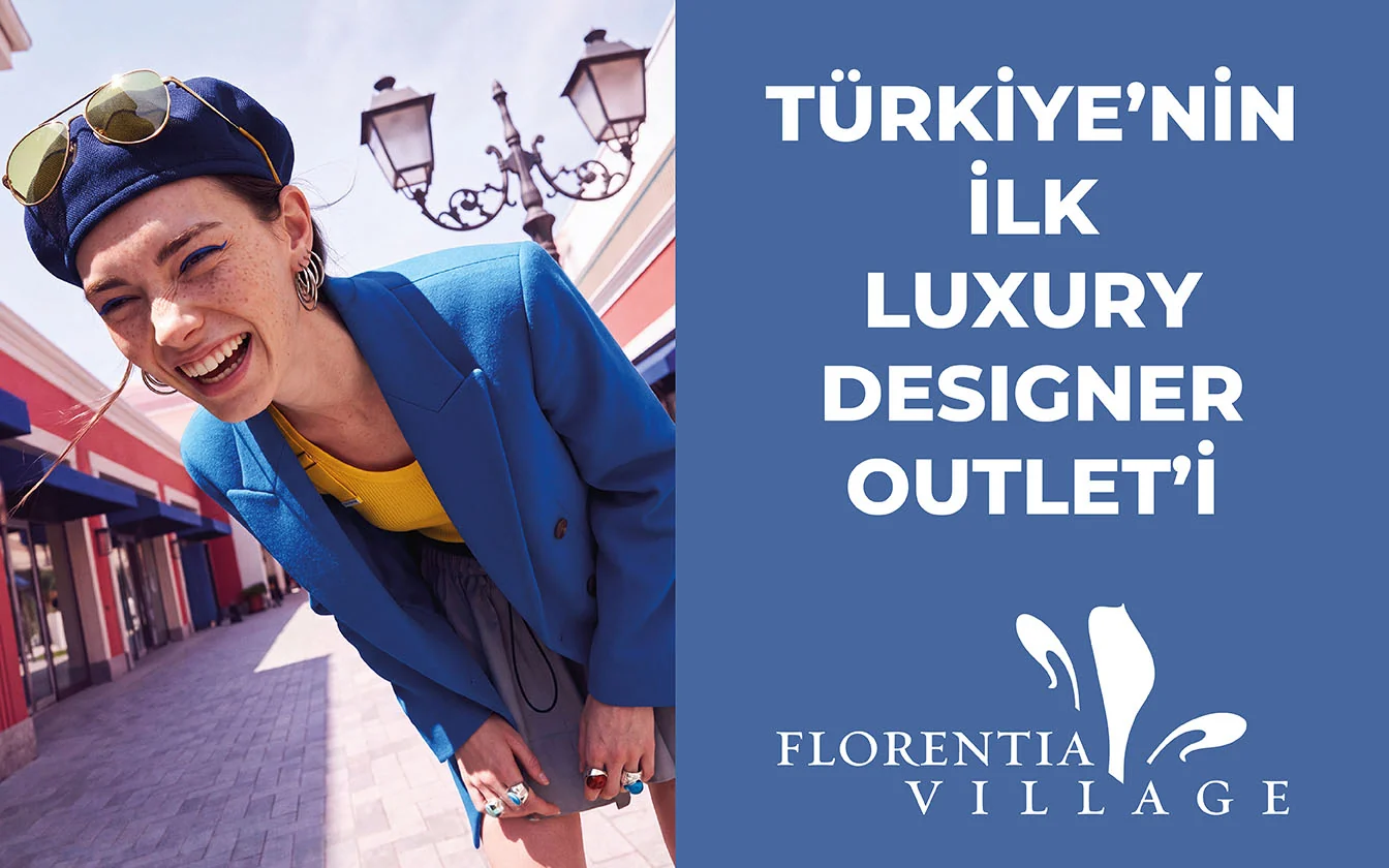 LED screen: a model in a navy beret and cobalt jacket leaning into frame - “Turkey’s first luxury designer outlet”